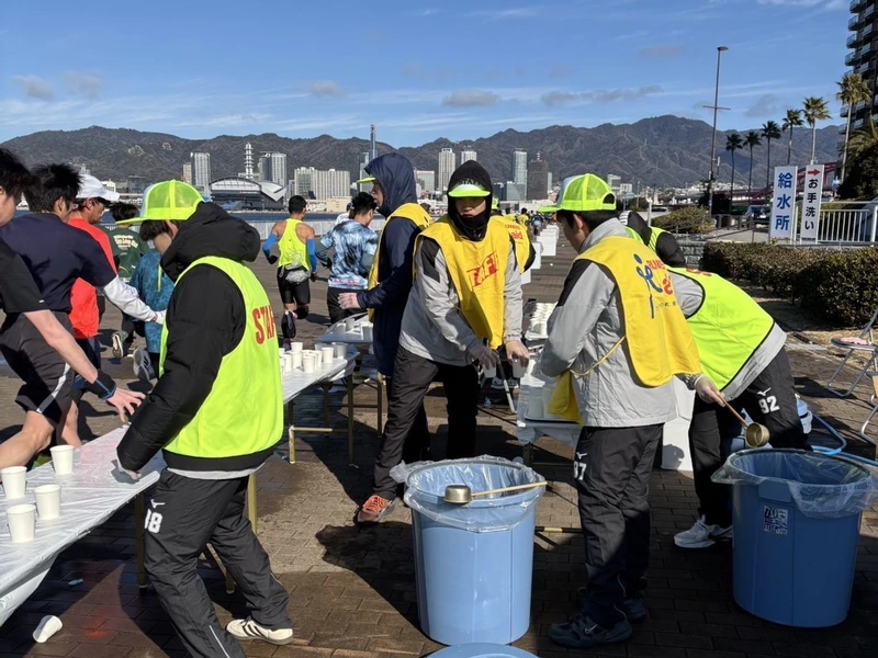 ランナーへ水を手渡しする学生たち